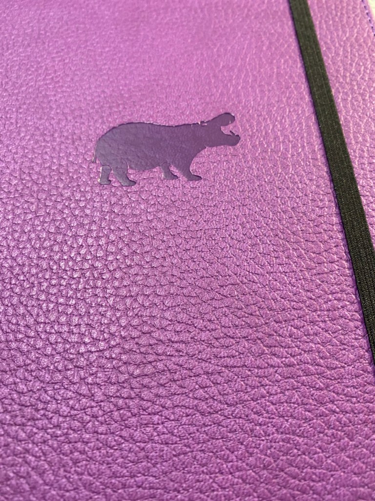 Hippo debossing on a purple faux leather, textured cover.