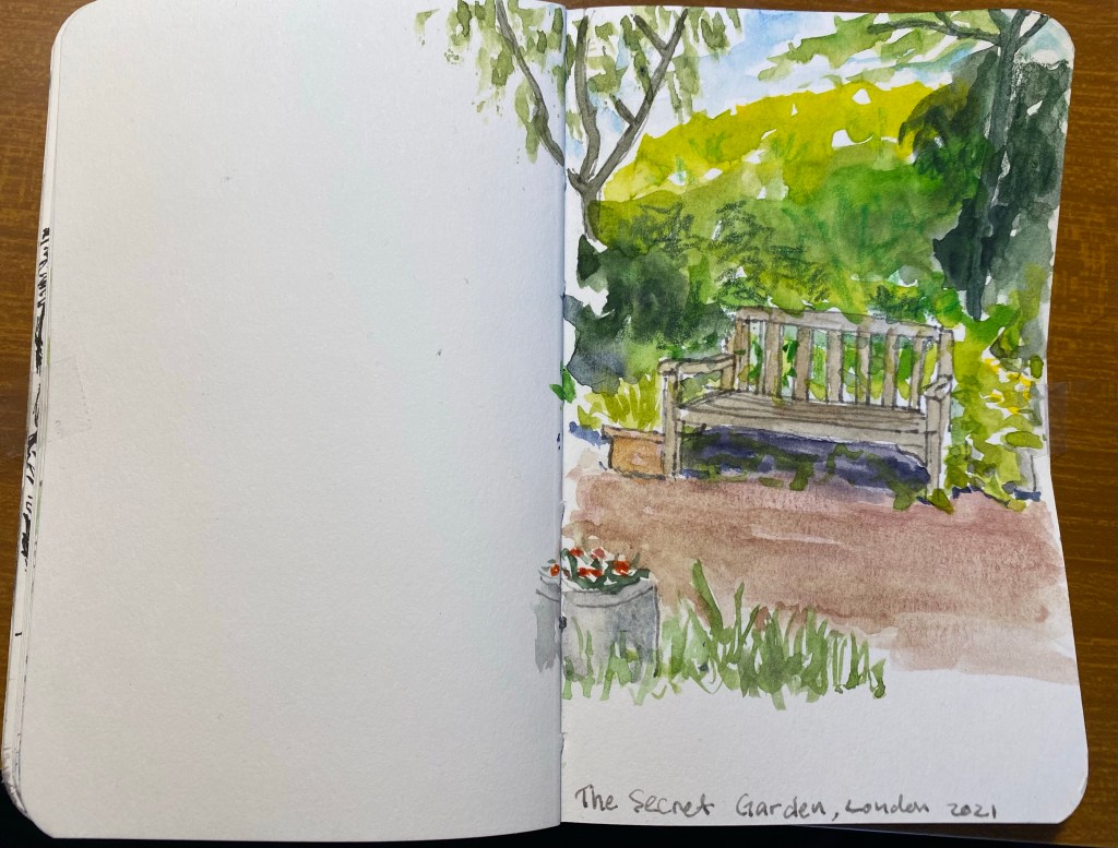 Watercolour sketch of a bench nestled in greenery at the side of a reddish path. 